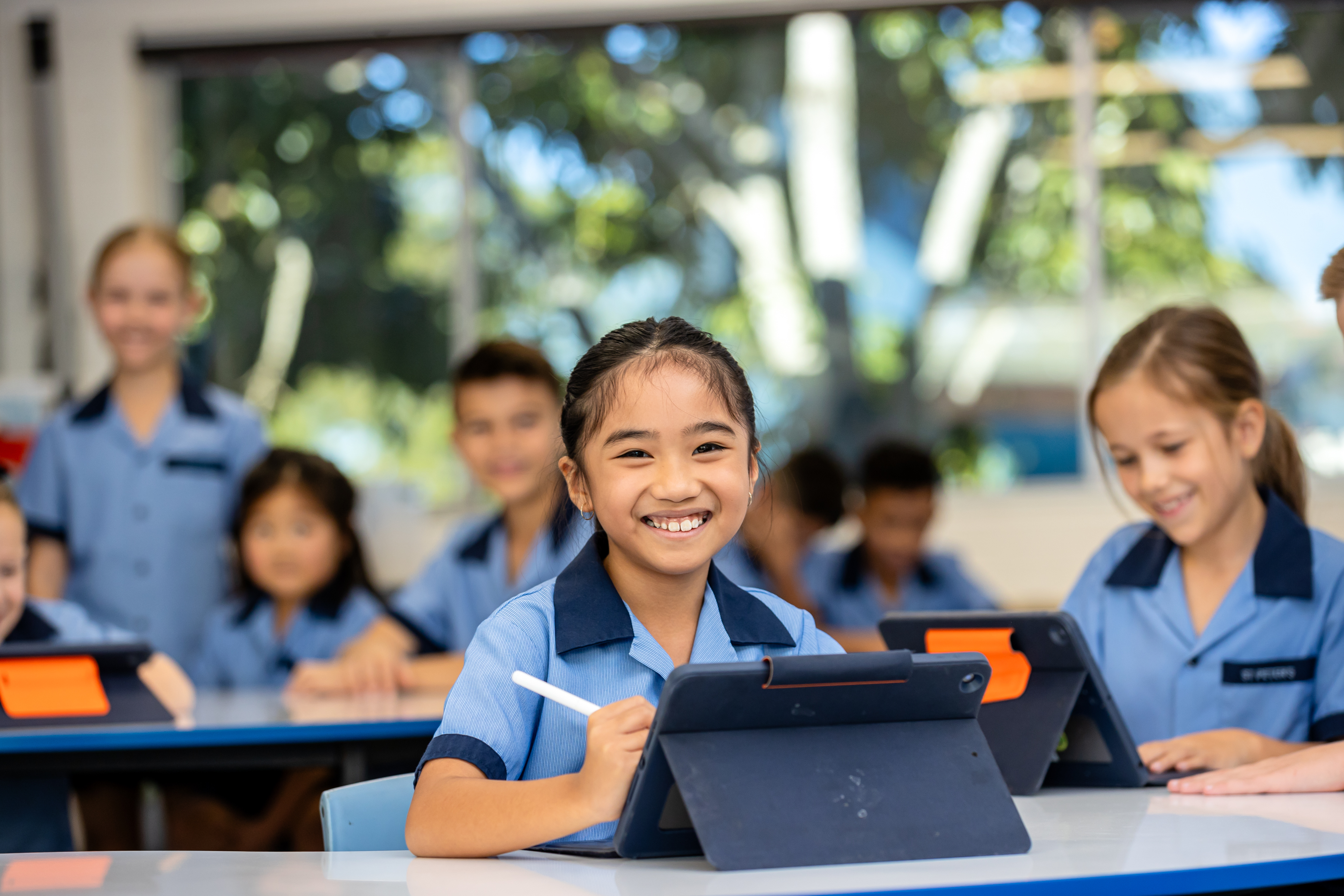 Students using tablets during a classroom learning activity with digital devices supporting engagement and learning