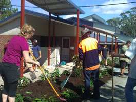 Staff and community members working together to plant garden beds in a school courtyard, supporting outdoor learning and sustainability